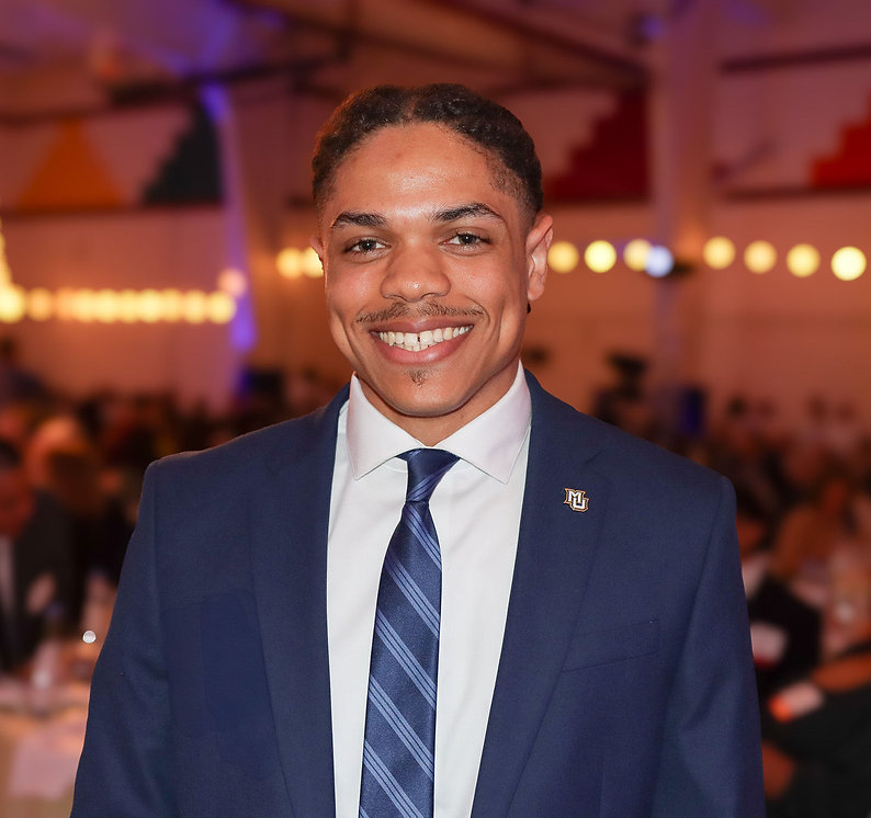 Image of Jaren Wilson in a blue suit with MU pin
